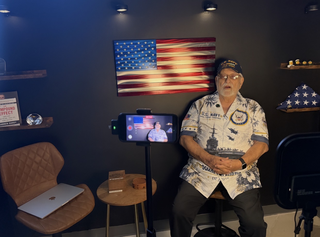 Behind the scenes: Vietnam veteran Mike Martin seated beneath an American flag while his story is recorded on a camera in front of him